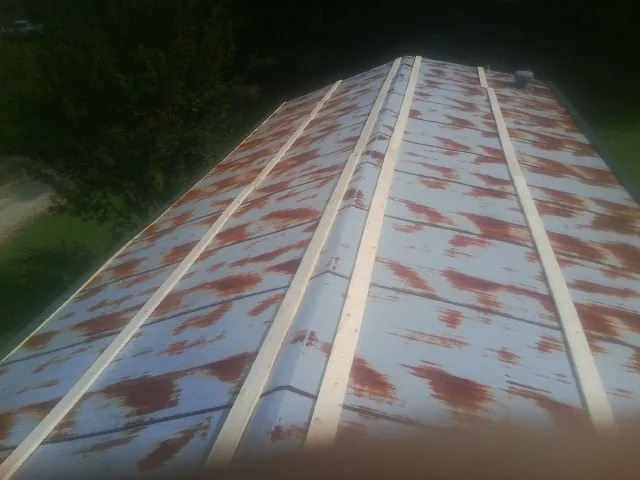 Rusted metal roof panels with new wood purlins before replacement — Storm Damage Roof Repair in Goodyear by Roofing Brothers