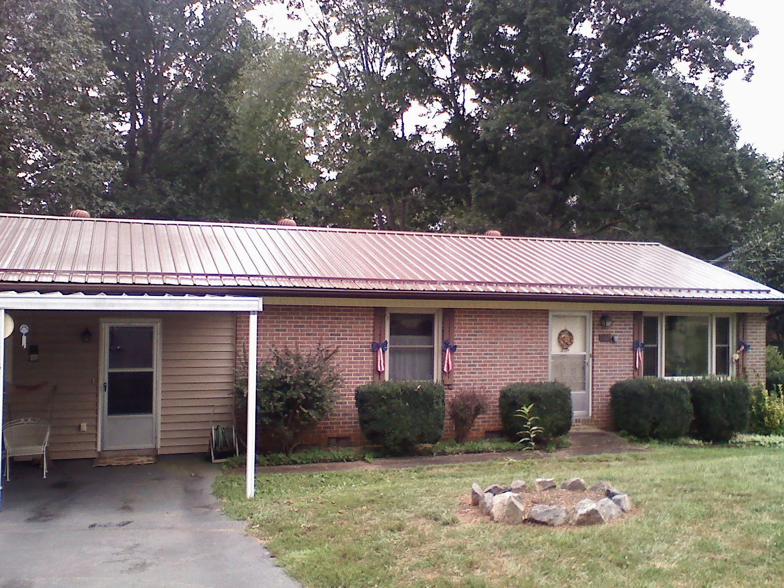Bronze metal roof and carport on a brick ranch home — Roof Repair work by our crew in Goodyear